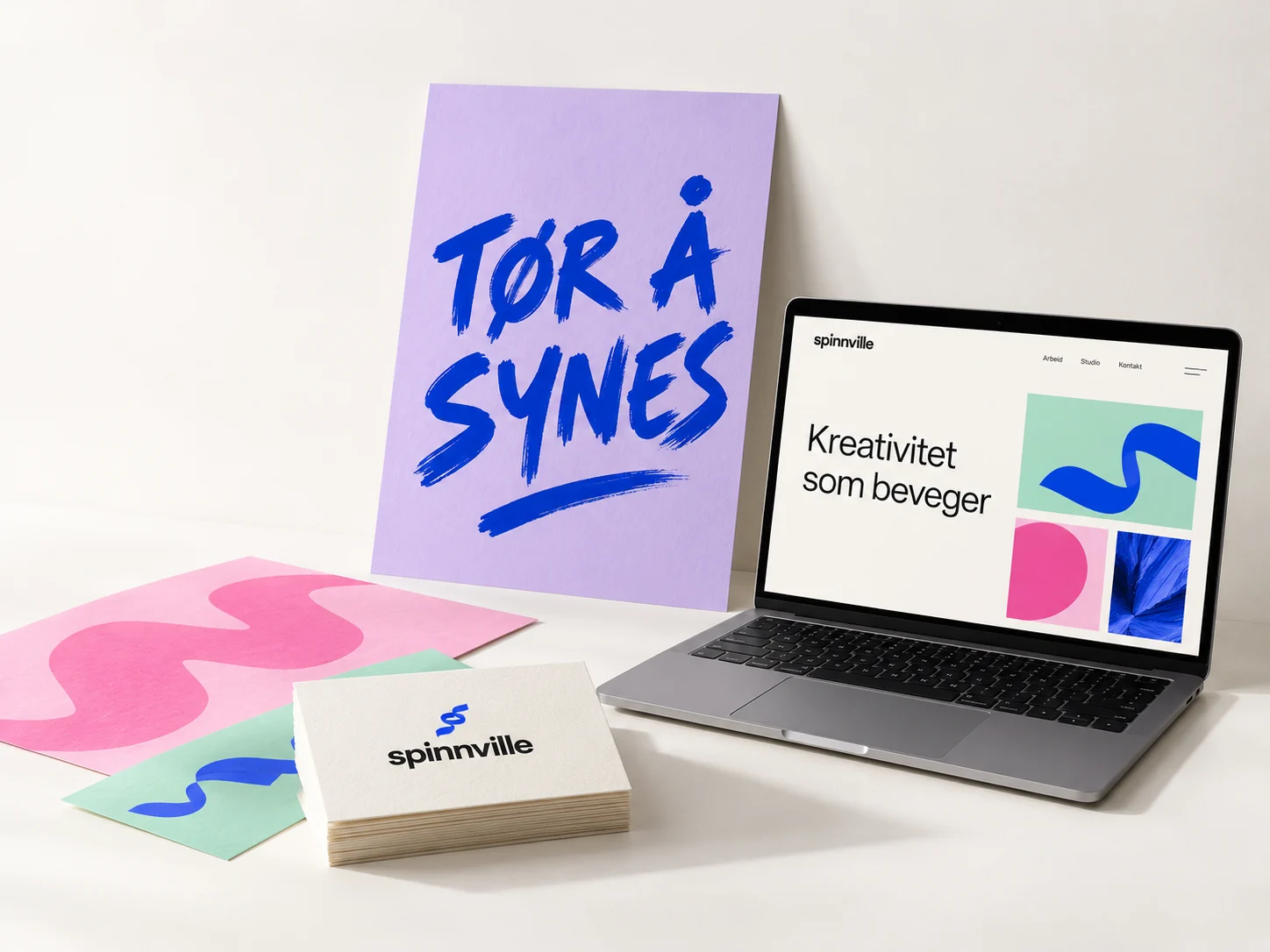 Designeksempel for Spinnville: lilla plakat, blå og rosa trykksaker, visittkort og nettside på en bærbar PC.